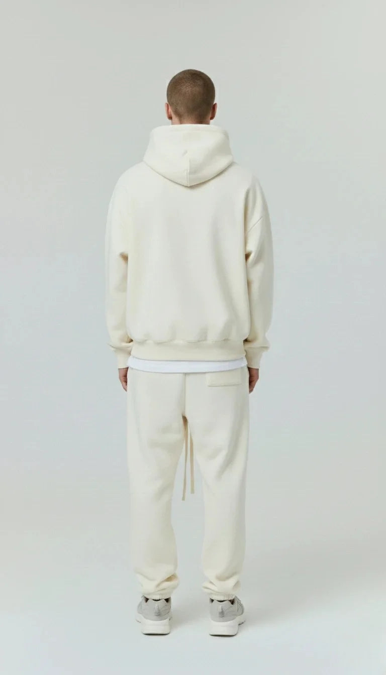 Person  wearing a cream-colored hoodie and pants on a white and showing backside of hoodie background - Mine outfit - best for casual wear , parties , date , university and collage's