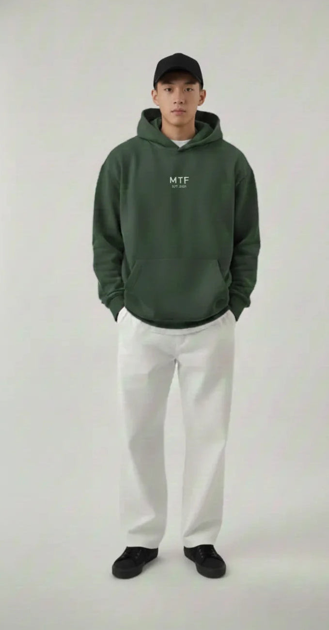 Person wearing a green hoodie with a logo on a white background